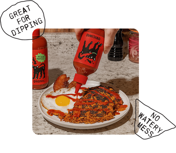 Hot sauce being poured onto a plate of food with 'Owning' brand hot sauce bottles.