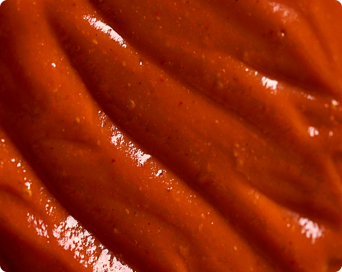 Close-up of smooth, red-brown sauce with a glossy texture.