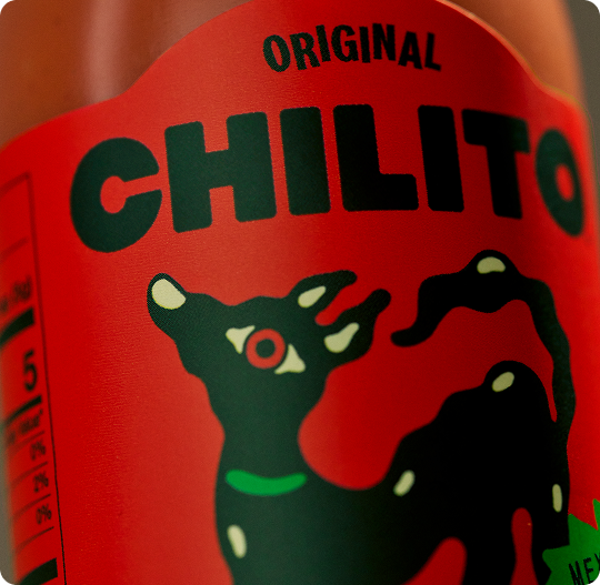 Red bottle label with 'Original Chilito' and a black dog illustration on a red background